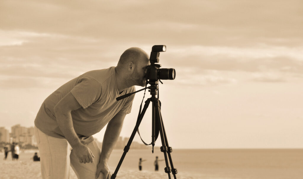 photo of professional photographer trevor ocean looking through the lens on naples beach